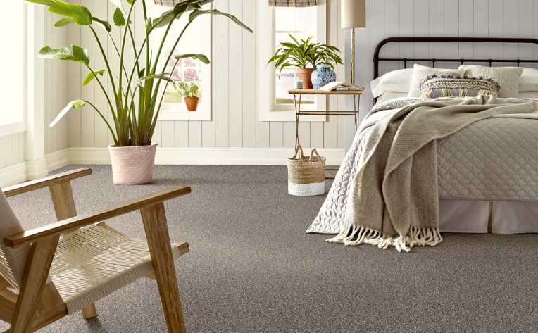 hypoallergenic carpet in bedroom with neutral colors, plants and rattan accents